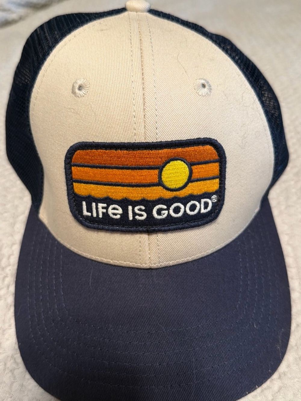 Life Is Good Cream and Navy Patch Trucker Hat with Sunset Logo
